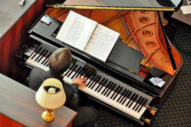 Músico tocando piano com Partituras Tocar de Cor ou Com Partitura