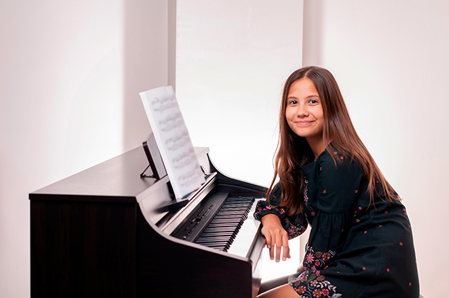 menina estudando repertório de piano
