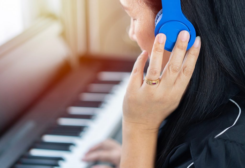 mulher tocando e ouvindo o som do piano