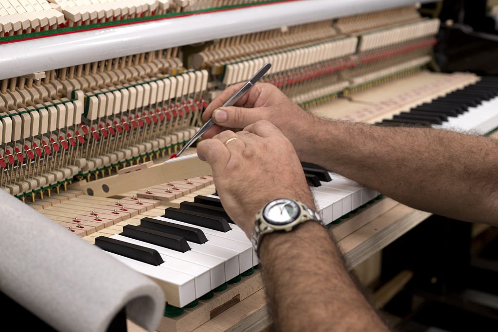 Técnico ajustando tecla de piano