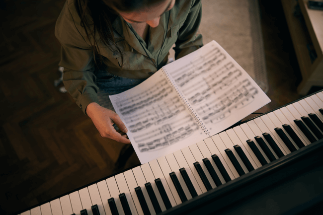 Pianista lendo partitura para tocar piano