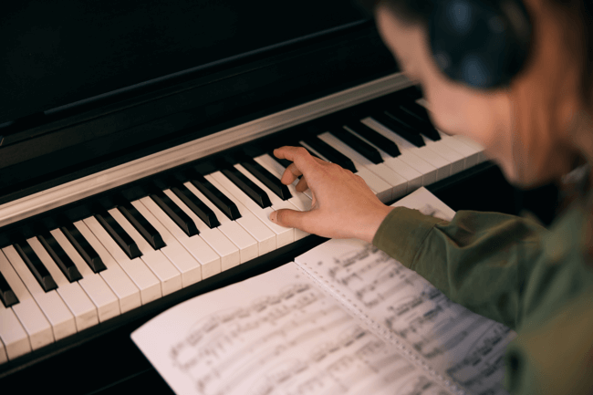 Pianista tocando piano com partitura